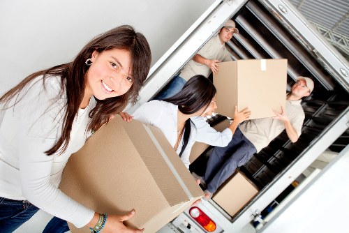 Local movers transporting household items through a Woodlands property entrance